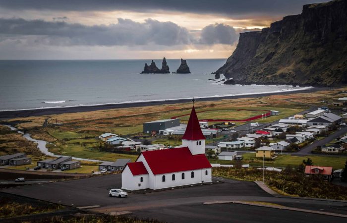 The white church in Vik i Myrdal is called Vík Church. Perched above the black sand shores of Vík í Mýrdal, the iconic red-roofed church looks out toward the wild Atlantic and the sea stacks of Reynisdrangar. This peaceful hilltop view captures the spirit of Iceland’s dramatic South Coast of Iceland — where powerful nature meets small coastal charm. A stop in Vík is always a highlight on a South Coast adventure with ICETREK Iceland.