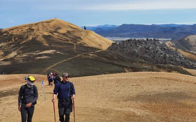 Group of hikers trekking through Iceland's rugged highlands with mountains in the background.