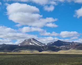 Dalastigur-blue-skies-fluffy-clouds-over-mountain-top-1680x840-2