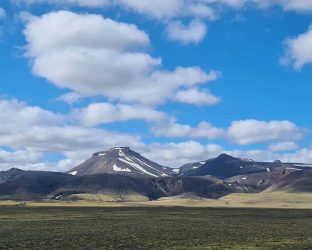Dalastigur-blue-skies-fluffy-clouds-over-mountain-top-1680x840-2