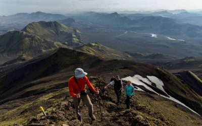Hikers ascending a mountain trail with scenic volcanic landscape in Iceland.