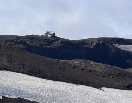 Remote mountain cabin on a snowy and rocky landscape in Iceland.