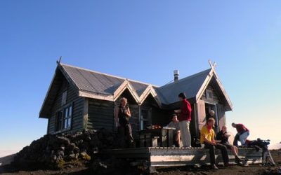 Group of hikers relaxing outside a mountain cabin during Icetrek expedition.